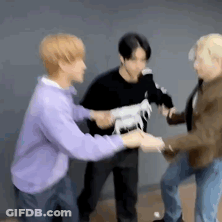 A Group Of Young Men Are Standing Next To Each Other Holding Hands While A Man Holds A Toy Horse . GIF
