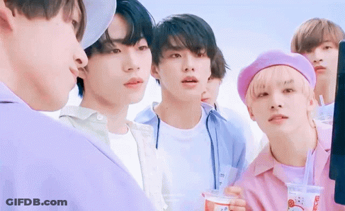 A Group Of Young Men Are Standing Next To Each Other In A Line . GIF