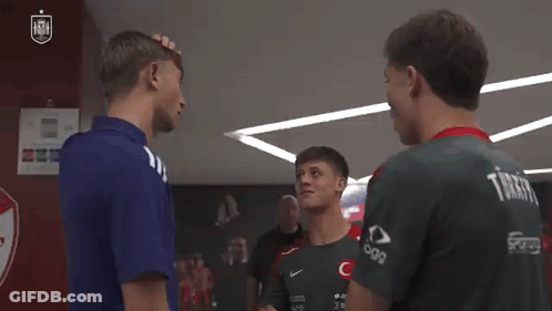 A Group Of Young Men Are Standing Next To Each Other In A Locker Room Talking To Each Other . GIF