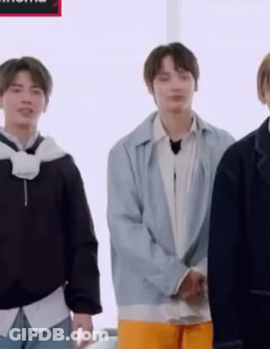 A Group Of Young Men Are Standing Next To Each Other In A Room And Smiling . GIF