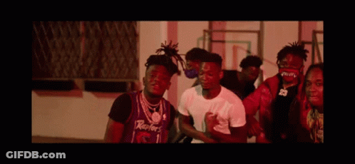 A Group Of Young Men Are Standing Next To Each Other In Front Of A Building . GIF