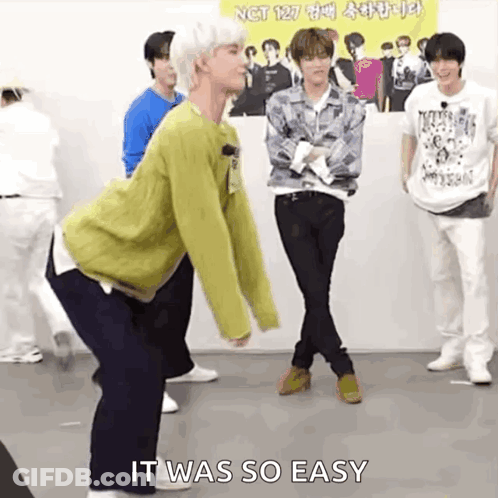 A Group Of Young Men Are Standing Next To Each Other On A Stage And One Of Them Is Dancing . GIF