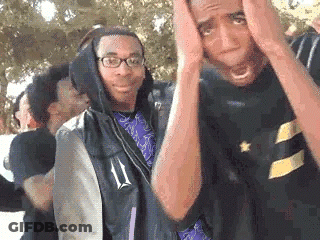 A Group Of Young Men Are Standing Next To Each Other With Their Hands On Their Head . GIF