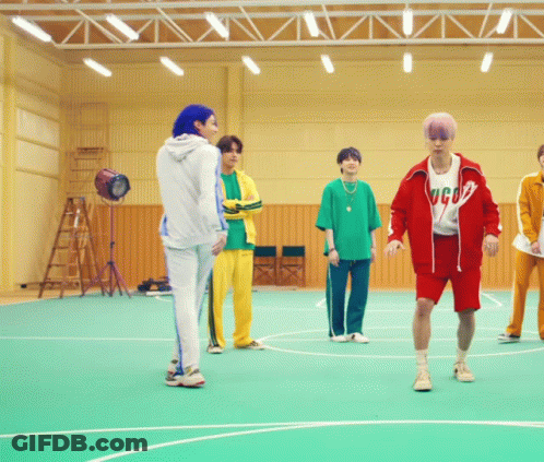 A Group Of Young Men Are Standing On A Basketball Court And One Of Them Is Wearing A Shirt That Says Gucci GIF