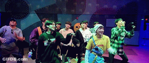 A Group Of Young Men Are Standing On A Stage Dancing . GIF