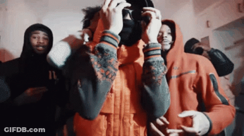 A Group Of Young Men In Hoodies Are Standing In A Room Taking A Picture With A Camera . GIF
