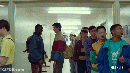 A Group Of Young Men Standing In A Hallway With A Netflix Logo On The Bottom GIF