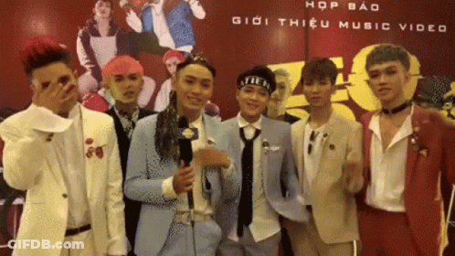 A Group Of Young Men Standing In Front Of A Sign That Says Hop Bao Giới Thiệu Music Video GIF