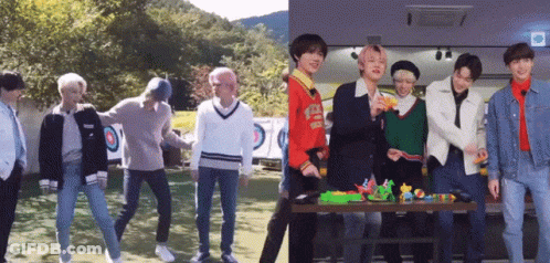 A Group Of Young Men Standing Next To Each Other In Front Of A Table With Toys On It GIF