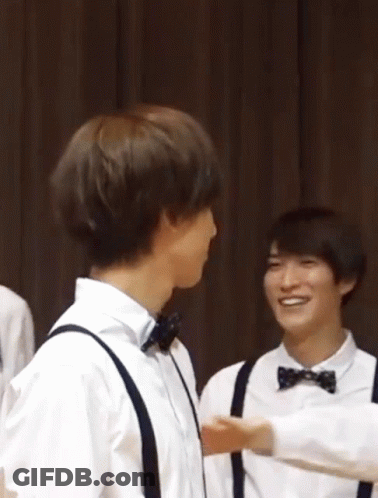 A Group Of Young Men Wearing Bow Ties And Suspenders Are Hugging GIF