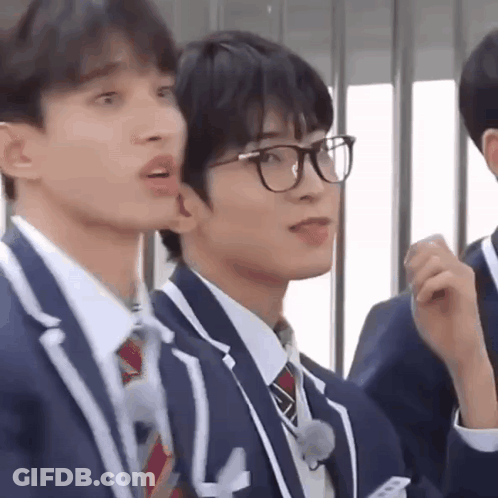A Group Of Young Men Wearing Suits And Ties Are Standing Next To Each Other . GIF