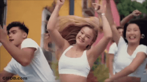 A Group Of Young People Are Dancing Together In Front Of A Yellow Building . GIF