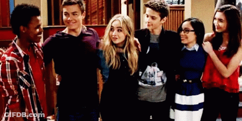 A Group Of Young People Are Posing For A Picture In A Room . GIF