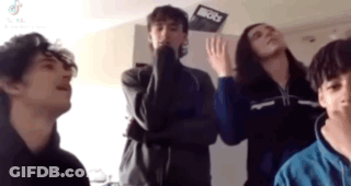 A Group Of Young People Are Standing In A Room With Their Arms Crossed . GIF
