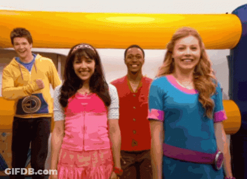 A Group Of Young People Standing In Front Of An Inflatable Bouncy House GIF