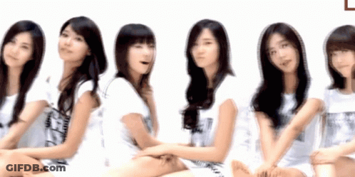 A Group Of Young Women Are Sitting In A Row With One Wearing A Shirt That Says ' A ' On It GIF