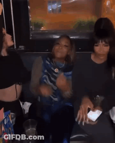 A Group Of Young Women Are Sitting Next To Each Other In A Room . GIF