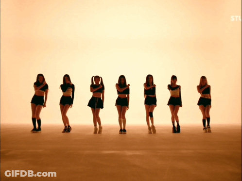 A Group Of Young Women Are Standing In A Row With Their Arms Crossed GIF