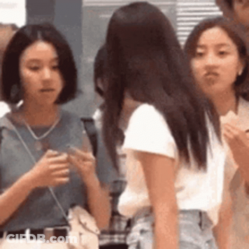 A Group Of Young Women Are Standing Next To Each Other In A Line . GIF