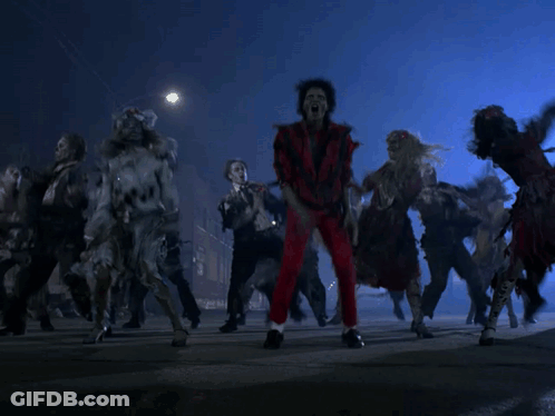 A Group Of Zombies Are Dancing On The Street In The Dark GIF