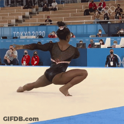 A Gymnast Performs On The Floor In Front Of A Sign That Says " Tokyo 2020 " GIF