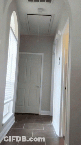 A Hallway In A House With A Ceiling Fan Above The Door GIF