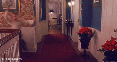 A Hallway With A Red Carpet And A Potted Plant On The Floor GIF