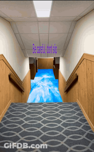 A Hallway With Stairs And A Blue Carpet That Says Be Careful Dont Slip GIF