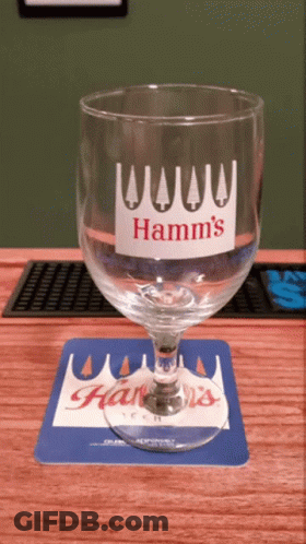 A Hamm 'S Glass Sits On A Blue And White Coaster GIF