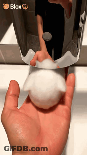 A Hand Holding A Soap Dispenser In Front Of A Blox Flip Logo GIF