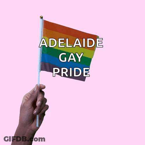 A Hand Holds A Small Rainbow Flag That Says Adelaide Gay Pride GIF