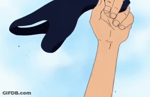 A Hand Is Holding A Black Object In The Shape Of A Shark GIF