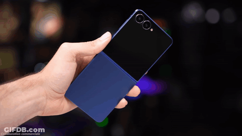 A Hand Is Holding A Blue Cell Phone With A Black Back GIF