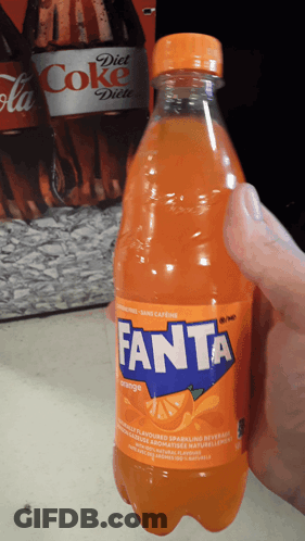 A Hand Is Holding A Bottle Of Orange Fanta Soda GIF