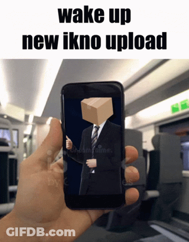 A Hand Is Holding A Cell Phone With A Man In A Suit And Tie With A Box On His Head GIF