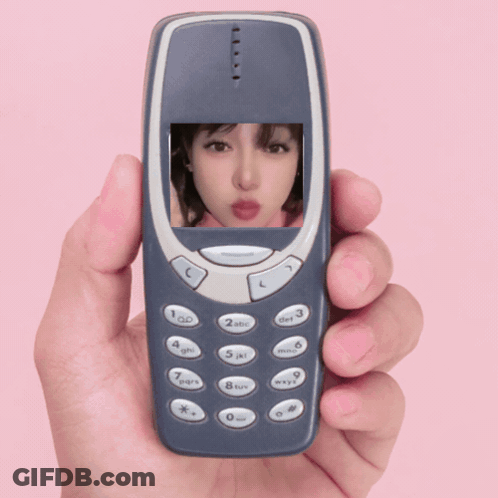 A Hand Is Holding A Cell Phone With A Picture Of A Girl On The Screen GIF