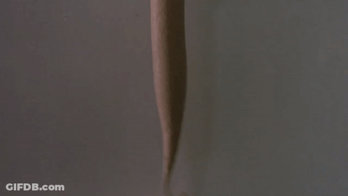 A Hand Is Holding A Cup Of Ice Cream With A Dispenser Attached To It GIF