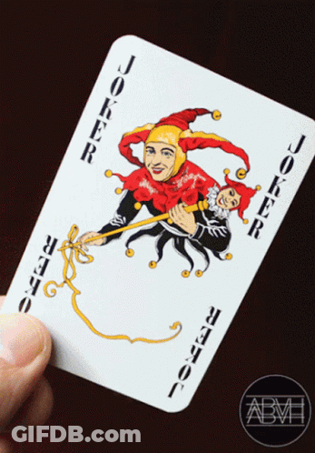 A Hand Is Holding A Joker Card With A Jester On It GIF
