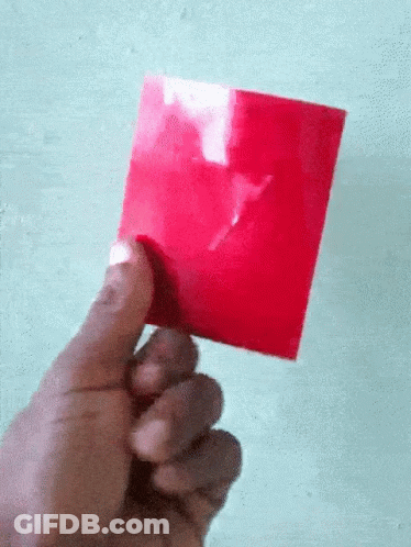 A Hand Is Holding A Red Piece Of Paper With A White X On It GIF