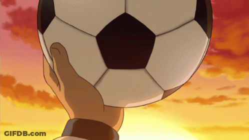 A Hand Is Holding A Soccer Ball In Front Of A Sunset Sky GIF
