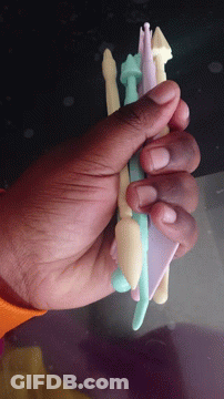A Hand Is Holding A Stack Of Plastic Pencils GIF