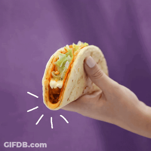 A Hand Is Holding A Taco With Lettuce And Cheese GIF