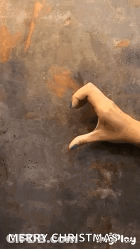 A Hand Is Making A Heart Shape With Its Fingers On A Concrete Surface . GIF