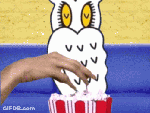 A Hand Reaches Into A Bucket Of Popcorn With An Owl On It GIF