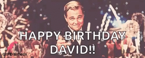 A Happy Birthday David Sign With A Man In A Tuxedo Holding A Toast GIF