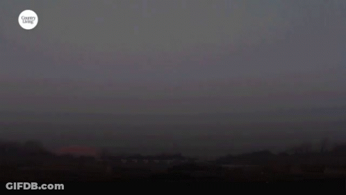 A Harvest Moon Is Shown In A Dark Sky GIF