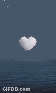 A Heart In The Middle Of A Fireworks Display Over The Ocean . GIF