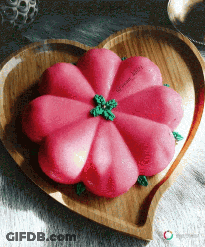A Heart Shaped Plate With A Pink Flower On Top GIF