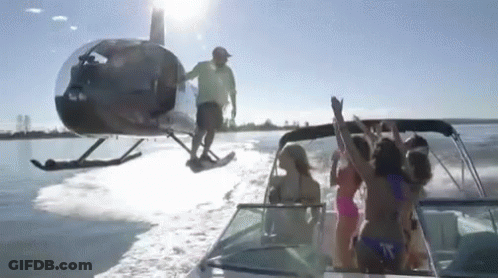 A Helicopter Is Flying Over A Boat Full Of People GIF
