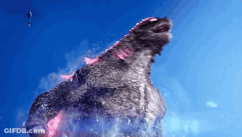 A Helicopter Is Flying Over A Giant Monster With A Blue Sky In The Background GIF